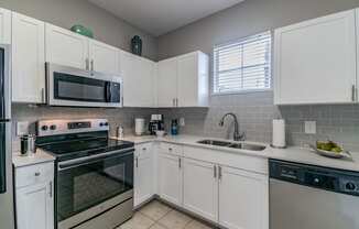 Kitchen appliances include range, microwave, refrigerator, garbage disposal, and dishwasher at Seasons at Westchase, Tampa