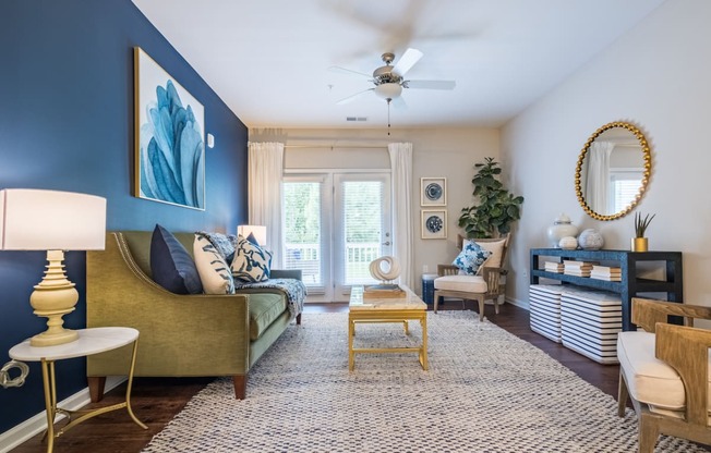 a living room with blue walls and a ceiling fan