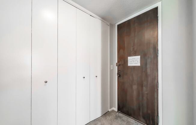 a bedroom with a medium sized white wardrobe and a large metal door