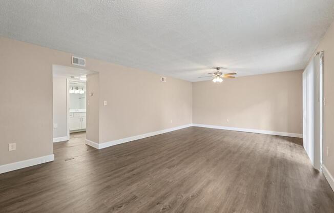 A room with wooden flooring and a ceiling fan.
