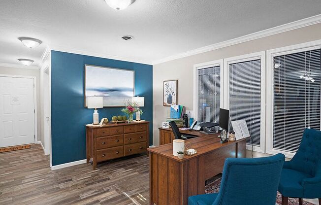 a living room with a desk and a chair