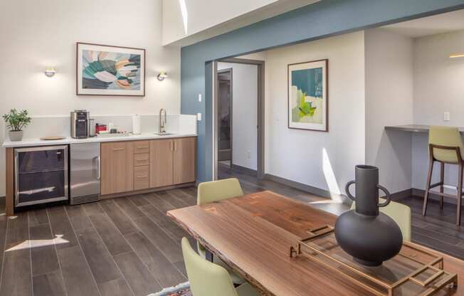 a dining room with a table and chairs and a kitchen with a sink