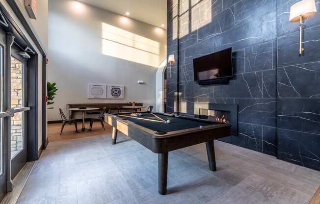 a game room with a pool table and a tv