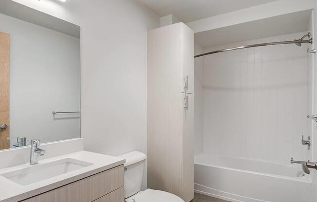 A white bathroom with a sink, toilet, and bathtub.