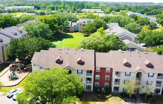 A bird's eye view of apartment buildings surrounded by trees.