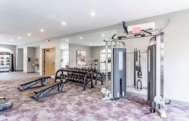 a spacious fitness room with treadmills and weights