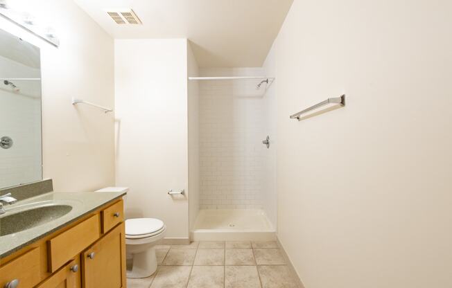 a bathroom with a toilet sink and bathtub at 26 West, Managed by Buckingham Urban Living, Indianapolis