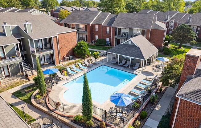 an aerial view of a swimming pool in front of an apartment building