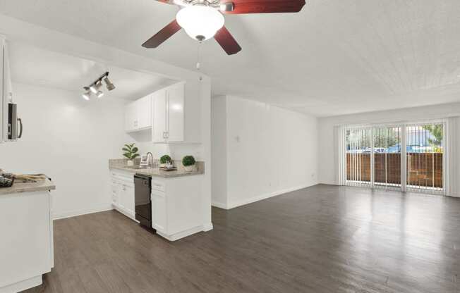 an empty living room and kitchen with a ceiling fan at Willow Tree Apartments, Torrance, CA