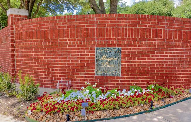 Lush front landscaping and brick façade of Montfort Place in North Dallas, TX, For Rent. Now leasing 1 and 2 bedroom apartments.