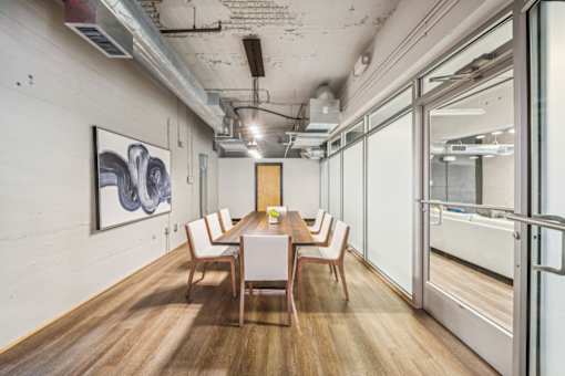 A conference room with a long table and chairs.