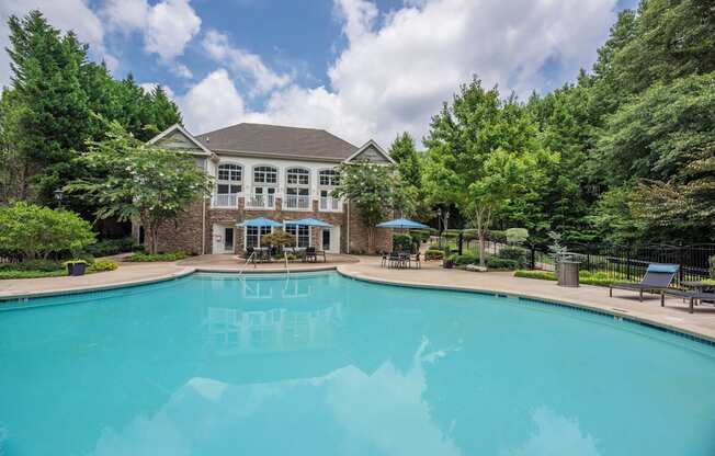 a large swimming pool with a mansion in the background