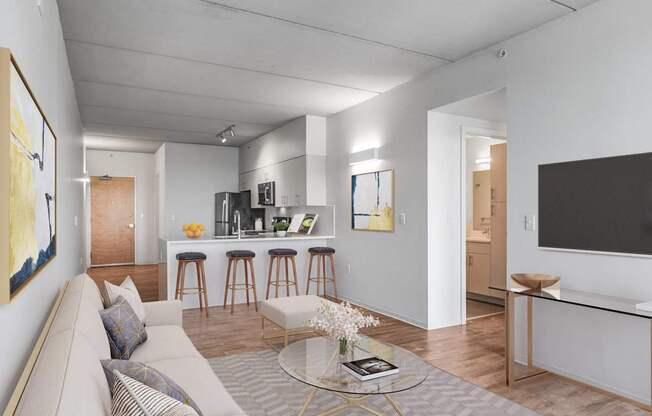 A modern living room with a grey sofa and a glass coffee table.