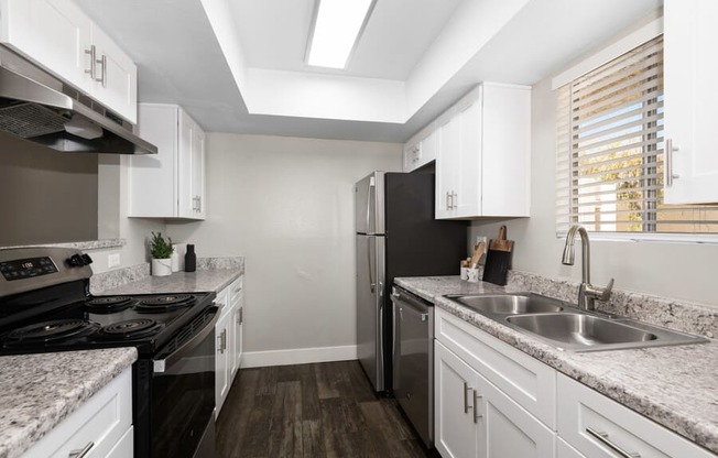 a kitchen with white cabinets and black appliances