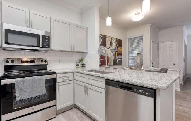 a kitchen with white cabinets and a granite counter top