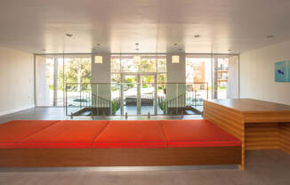 a large orange bench in a room with glass doors