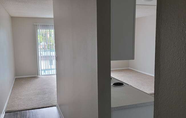 Entry hallway view of living room and kitchen at La Mesa Village Apartments in La Mesa, California.