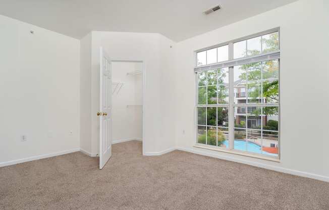 a bedroom with a large window and a door to a pool