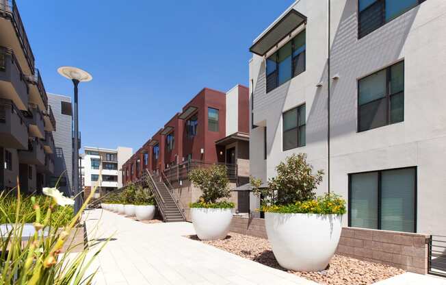 a row of apartment buildings with large planters in front of them