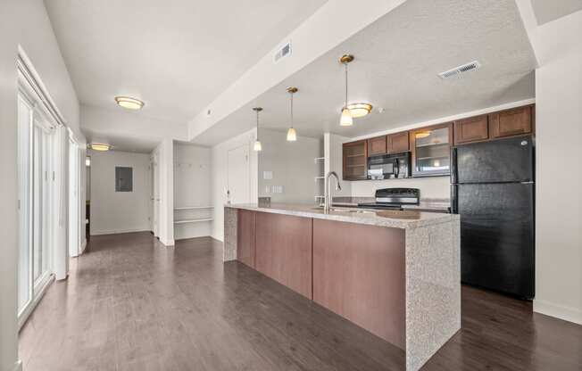 a kitchen with an island and a black refrigerator