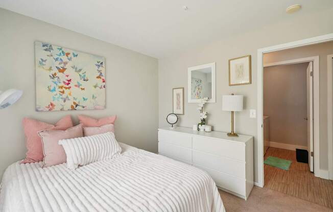 A bedroom with a large bed and a painting on the wall.