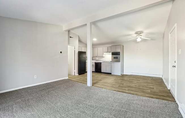 A spacious living room with a kitchen in the background.