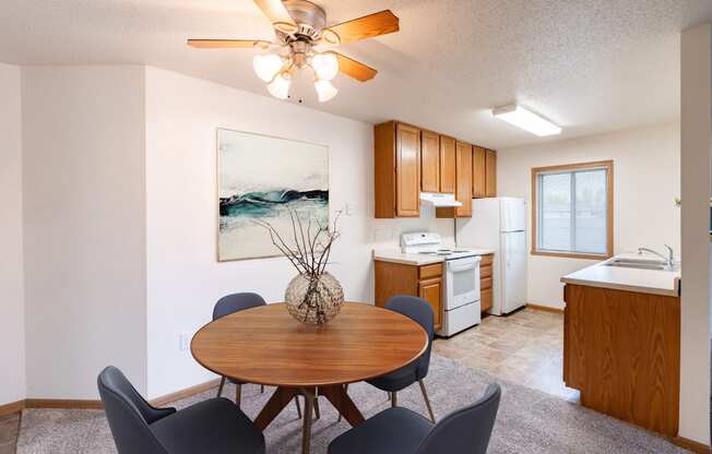 a dining room with a table and chairs and a kitchen. Fargo, ND Oxford Apartments