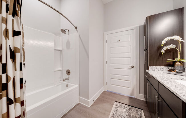 a bathroom with a shower and a sink and a bath tub