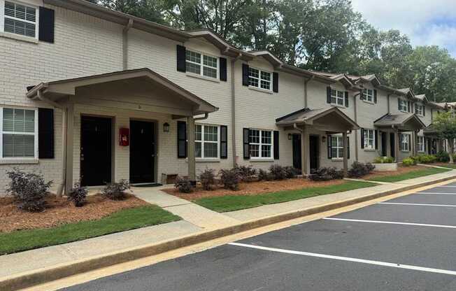 A row of houses with a parking lot in front.