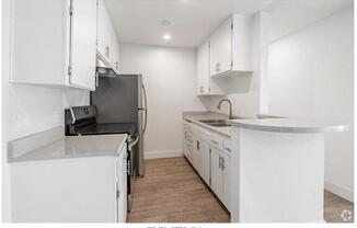 a kitchen with white cabinets and a stove and a refrigerator