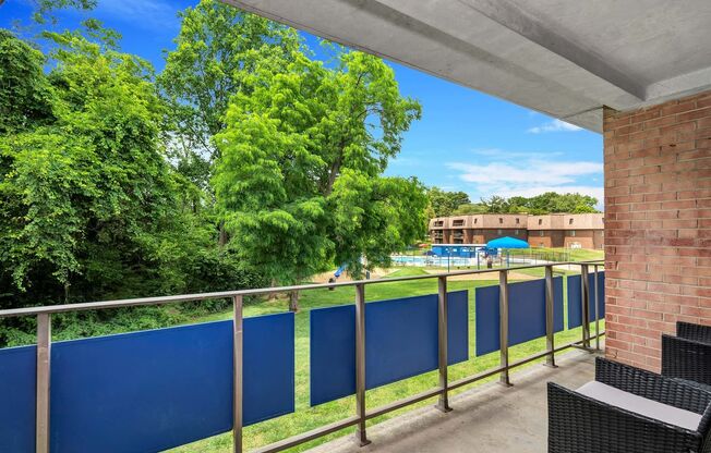 a balcony with a blue fence and a pool in the background