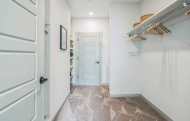 a hallway with a closet and a white door at Preston Ridge, Cary, 27513