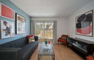 a living room with a gray couch and a glass coffee table