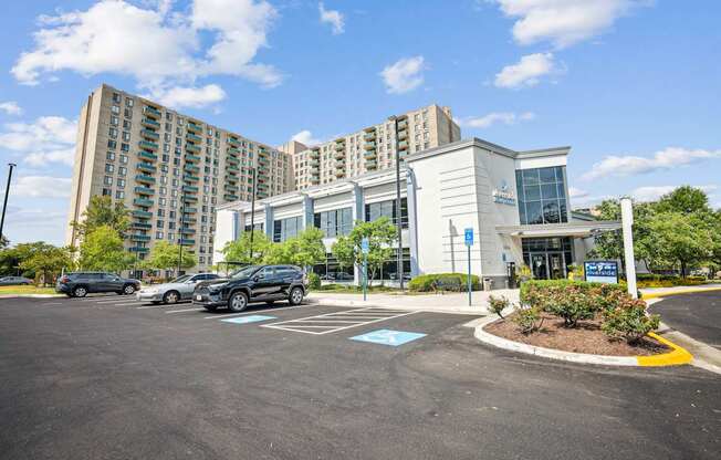 A parking lot in front of a building with a blue sign.