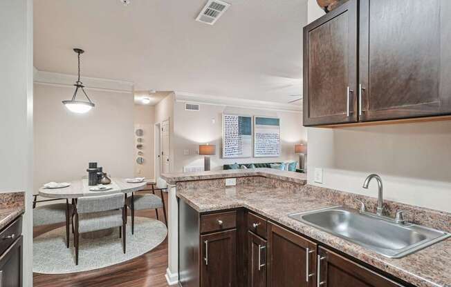 A kitchen with brown cabinets and a granite countertop.