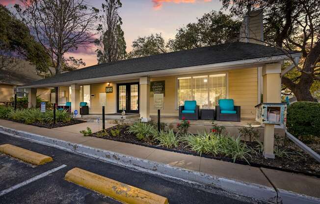 A building with a porch and a mailbox in front of it.