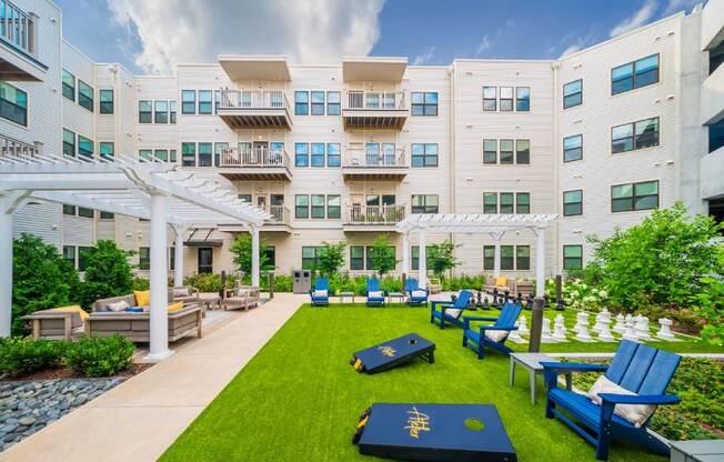 A white building with blue chairs and tables in front.