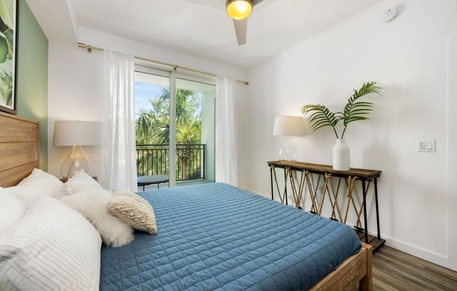 a bedroom with a blue bed and a balcony