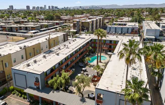 a view of the building from above with a pool and palm trees in the foreground