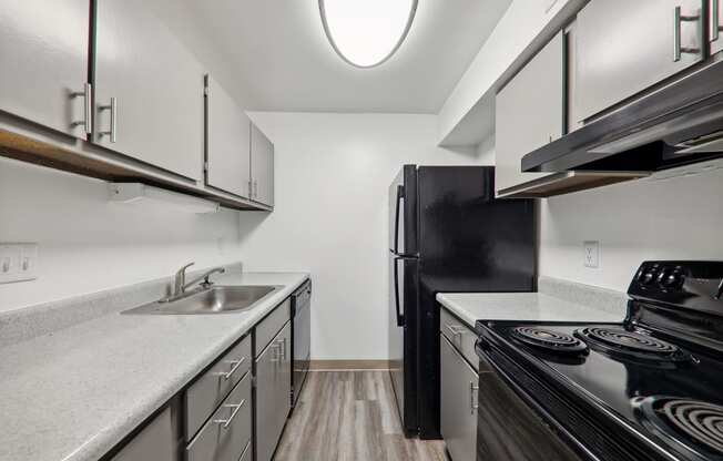 a kitchen with white cabinets and a black stove and refrigerator