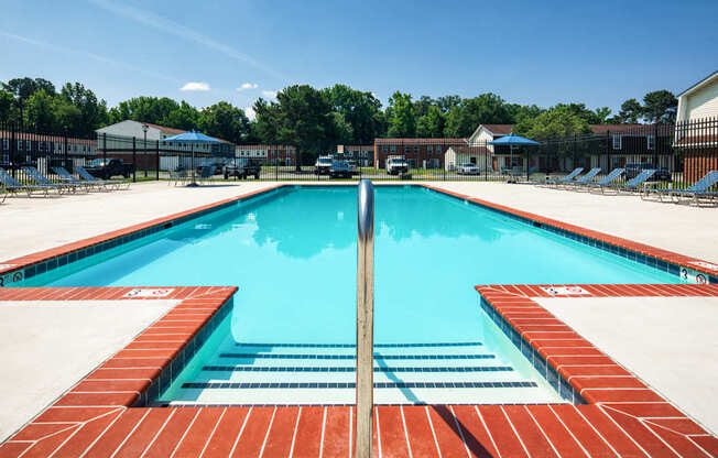 A large rectangular pool with a red tile edge and a blue water surface.