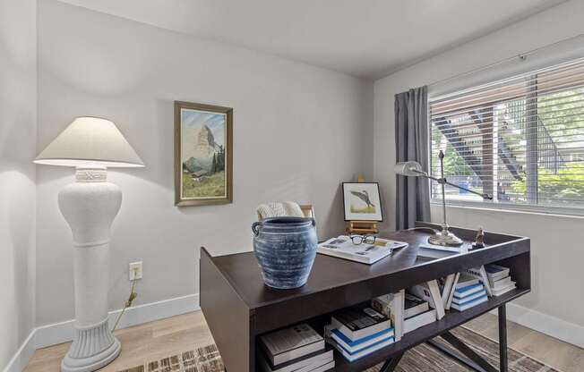 an office with a desk and a lamp and a window