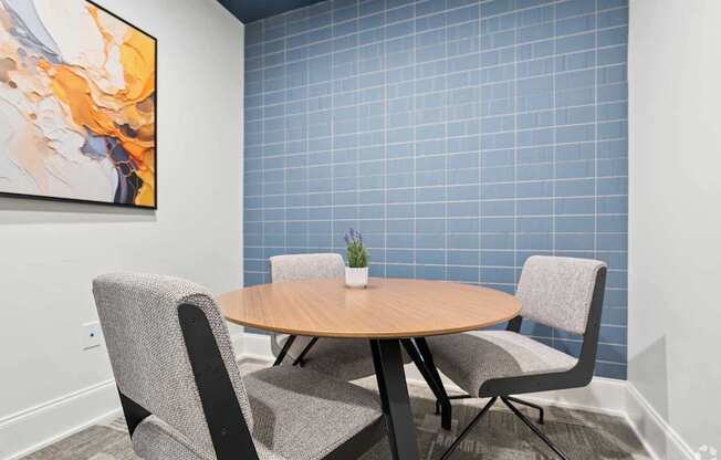 A round table with two chairs and a plant on it.