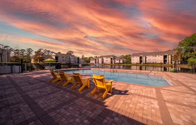 A pool surrounded by yellow sun loungers.