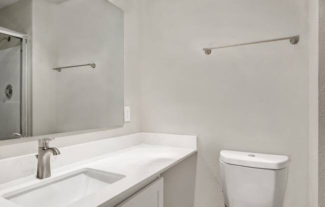 a bathroom with a sink and a toilet and a mirror at 2000 Lake Washington Apartments, Washington, 98056