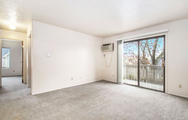 a living room with a sliding glass door and a balcony