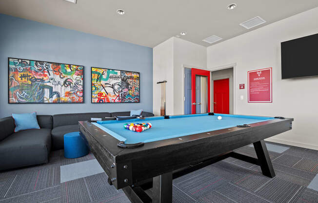 a games room with a pool table and a tv
