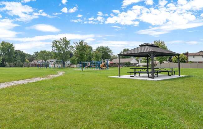 A park with a picnic table and a playground.