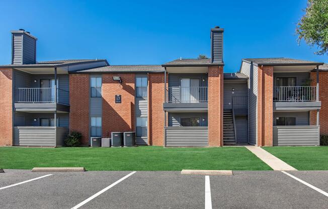 a large brick building with grass in front of a house