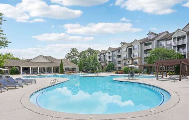 A large outdoor swimming pool surrounded by apartment buildings.